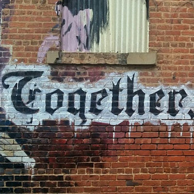 Together we words spray painted on a building